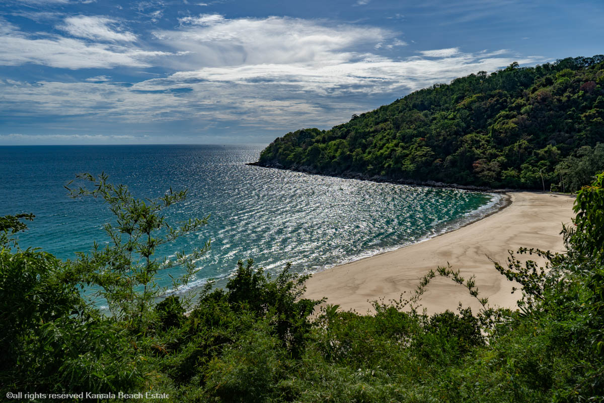 Beautiful view of Karon Noi Beach with clear blue waters and lush greenery.