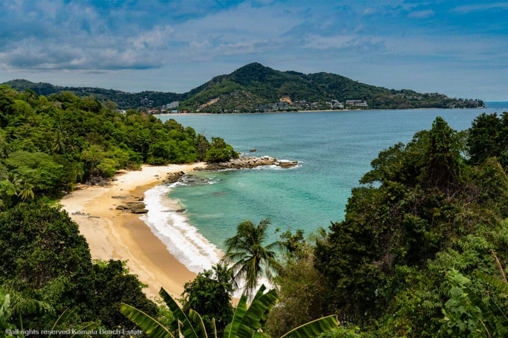 A serene view of Laem Singh Beach in Phuket, surrounded by lush greenery and turquoise waters.