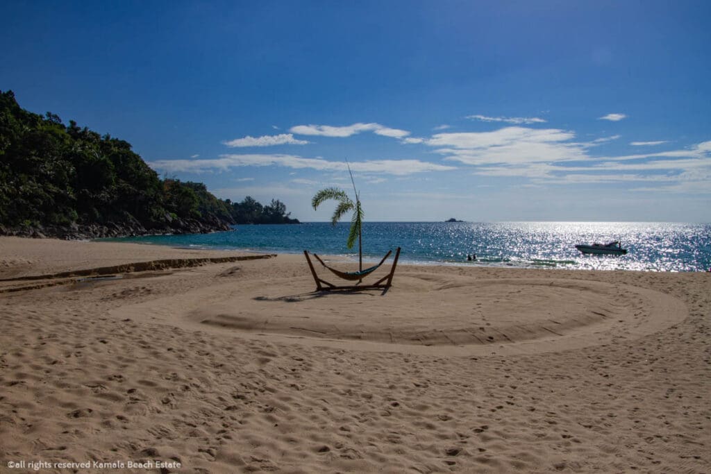 Hammock on the sandy shores of White Beach, Phuket, with a serene ocean view and lush greenery in the background.