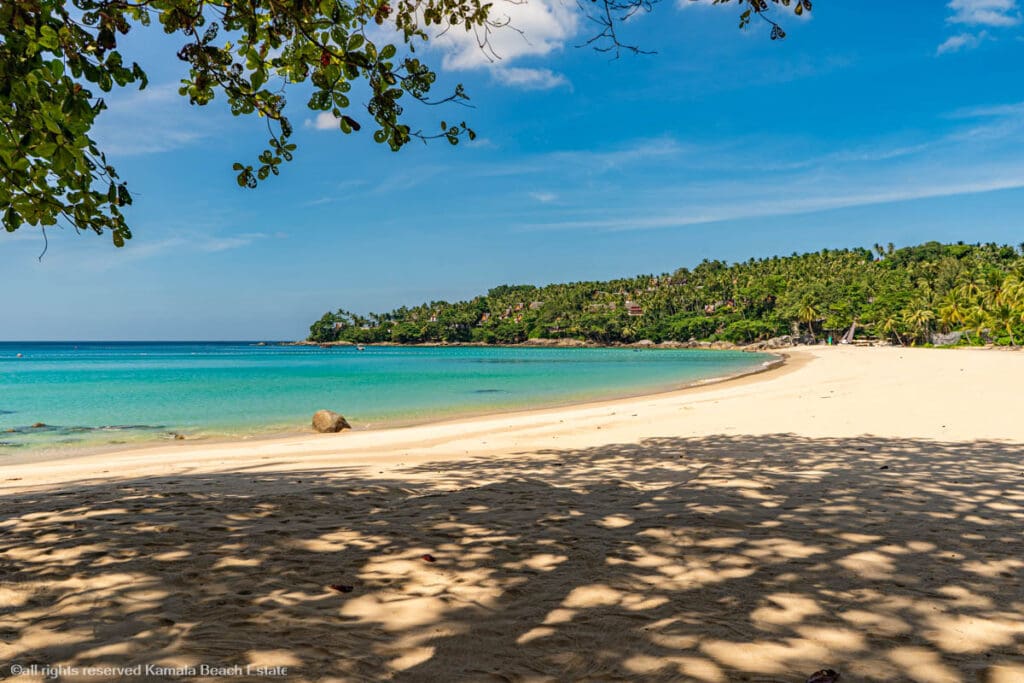 Pansea Beach in Phuket with clear turquoise waters, fine white sand, and lush greenery.