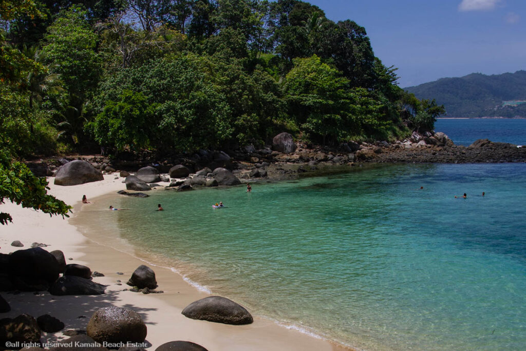 Scenic view of Paradise Beach with clear blue waters and surrounding greenery.