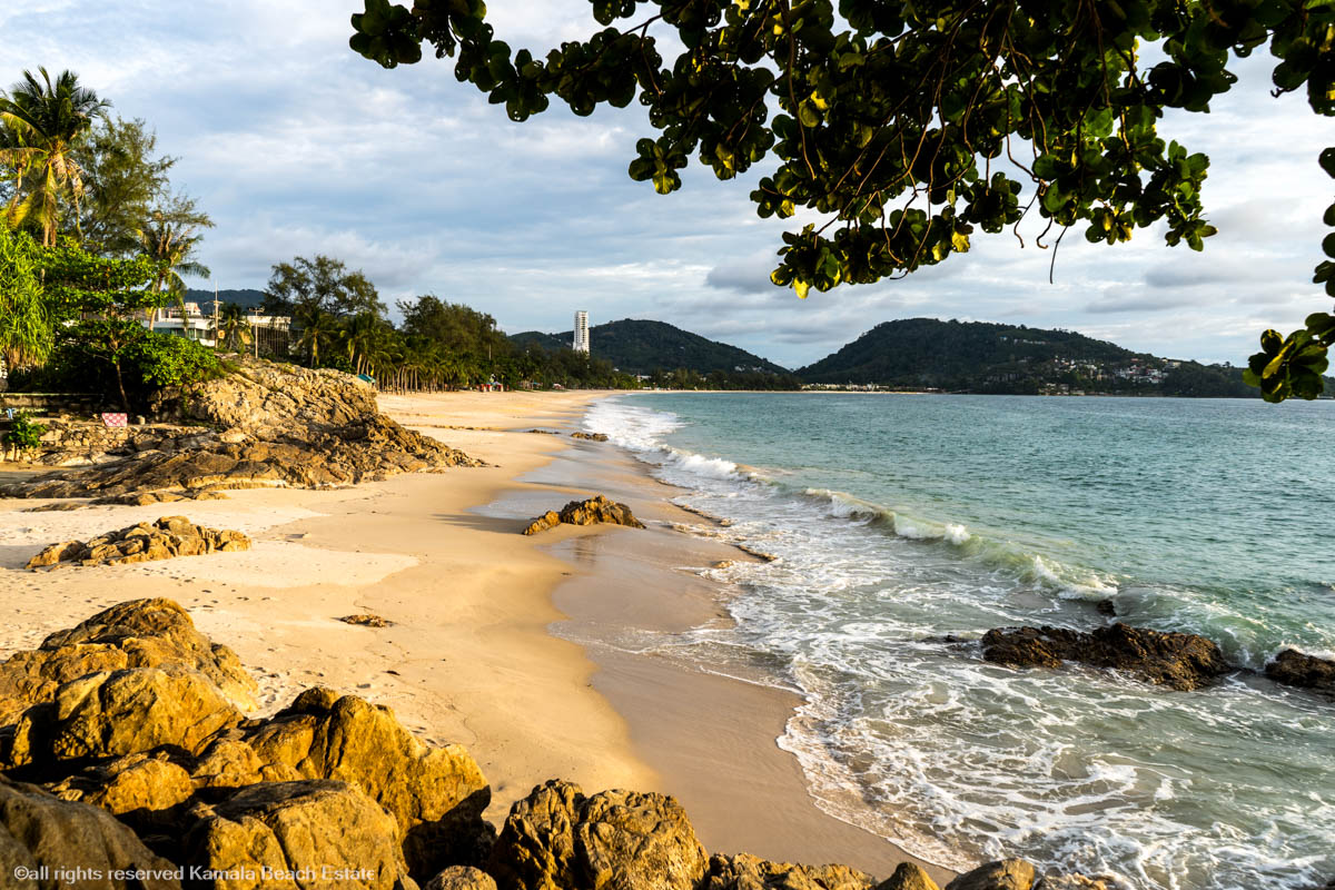 Sunset view of Patong Beach with people enjoying the shore and vibrant sky.