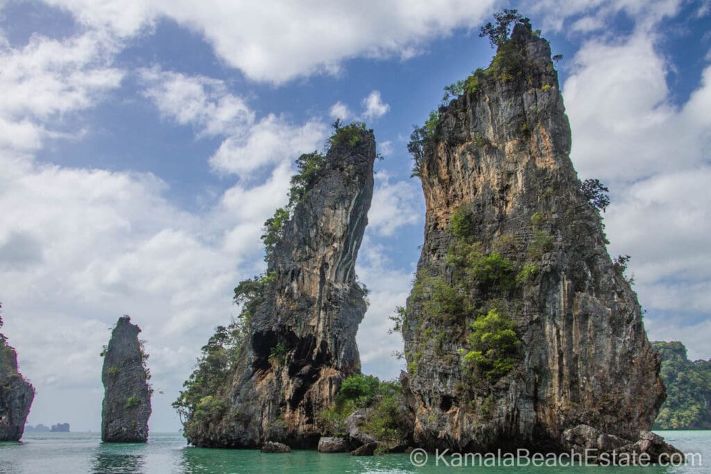 Towering limestone cliffs rising from the turquoise waters of Phang Nga Bay, Thailand.