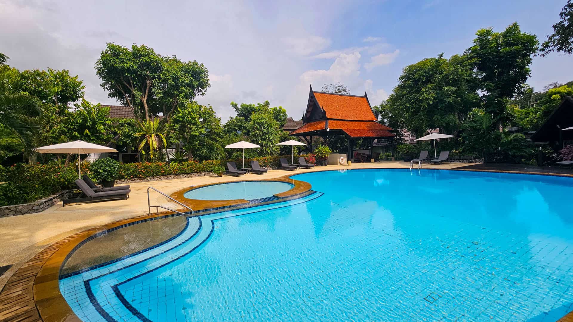 The main swimming pool and adjoining children's pool beside a Thai pavilion